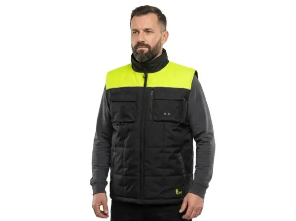 Kamizelka Seattle czarno-żółta - widok z przodu na modelu ubranym w szarą bluzę. Widoczny czarny, pikowany materiał, jaskrawożółty panel na ramionach, wysoki kołnierz oraz kieszenie z patkami na piersi - wycięte na białym tle studyjnym.