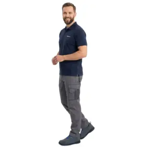Szaro-niebieskie półbuty robocze GOBI S1 zaprezentowane na uśmiechniętym modelu w granatowej koszulce polo i szarych spodniach roboczych, ujęcie całej sylwetki z boku w pozie imitującej krok, wycięte na białym tle studyjnym.