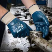Niebieskie rękawice powlekane CXS PELA z jasnym mankietem na dłoniach mechanika trzymającego