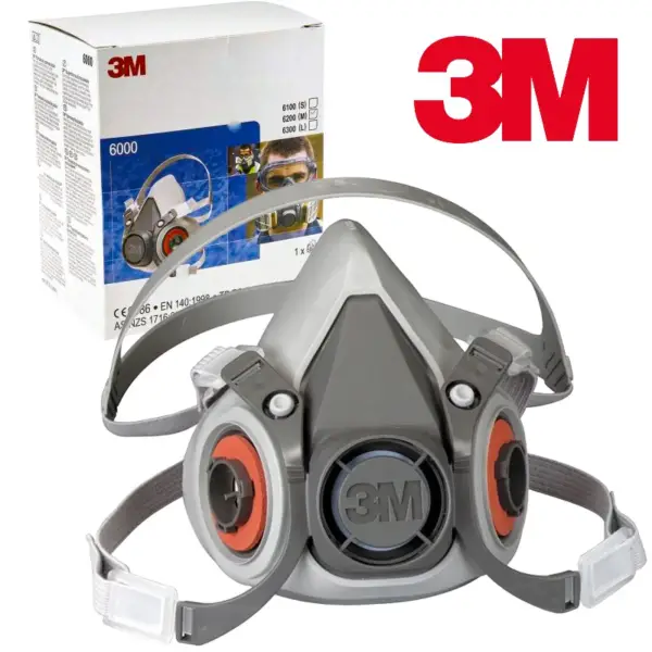 POLMASKA 3M 6300 maska bhp polmaska 3M 6300 ochronna - szaro-czarna z pomarańczowymi elementami mocującymi filtry i paskami nagłownymi, ułożona przodem pod kątem obok oryginalnego opakowania kartonowego i czerwonego logo - wycięte na białym tle studyjnym