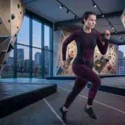 Spodnie termoaktywne SEAMFLEX LADY w kolorze bordowo-czarnym, zaprezentowane na modelce w dynamicznej pozie biegu z widocznym różowym logo CXS na łydce, na tle nowoczesnej sali ze ściankami wspinaczkowymi.